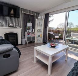 A living room with a fireplace and television at Grosvenor 10 in Llanarmon-Yn-Ial