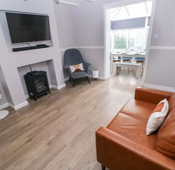 A living room with a television and sofa at The Wool Pack in Tenby