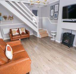 A living room with a sofa and television at The Wool Pack in Tenby