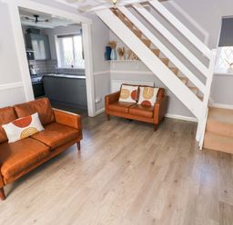 A living room with sofas and a staircase at The Wool Pack in Tenby