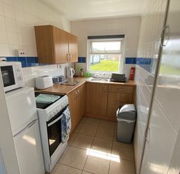 A kitchen with appliances and a window at Chalet 57 California, Norfolk