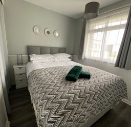 A bedroom with a bed and nightstand at Chalet 57 in California, Norfolk