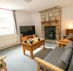 A living room with a sofa and television at NO 10 in Fortuneswell