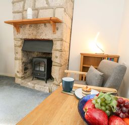 A living room with a fireplace and wooden furniture at NO 10 Fortuneswell