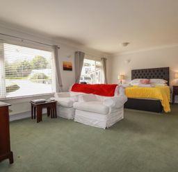 A bedroom with a bed and armchair at Tregoning annex in Lerryn near Lostwithiel