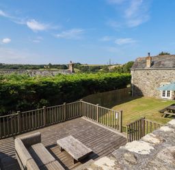 An outdoor area with a deck and furniture at Bryher Cottage in St Mawgan