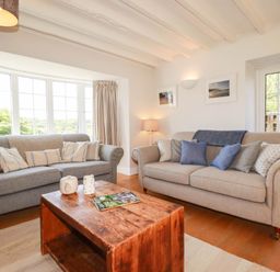 A living room with sofas and a coffee table at Bryher Cottage St Mawgan