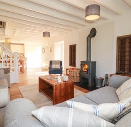 A living room with a fireplace and a coffee table at Bryher Cottage in St Mawgan