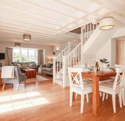 A living room with sofa and dining table at Bryher Cottage St Mawgan