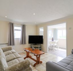 A living room with a sofa and television at Watersmeet - 85 @ Park Avenue Holiday Village, Leysdown-On-Sea, Kent