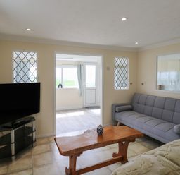 A living room with a television, sofa, and a table at Watersmeet - 85 @ Park Avenue Holiday Village, Leysdown-On-Sea, Kent