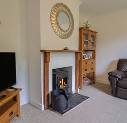 A living room with a television and a fireplace at 2 North Road Maiden Newton, Dorset