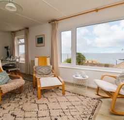 A living room with chairs and a window view at Wootton Gray in Penzance