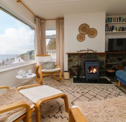 A living room with a fireplace and sofa at Wootton Gray in Penzance