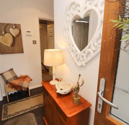 A hallway with a mirror and chest of drawers at Jodene Lodge, Redwood 2 in Bowness-On-Windermere