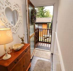An entrance hall with a table and lamp at Jodene Lodge, Redwood 2, Bowness-On-Windermere