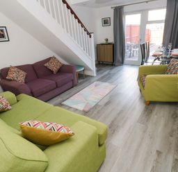 A living room with a sofa, armchairs, dining table, and window at The Gower Gateway Gowerton near Swansea