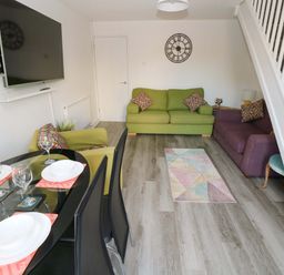 A living room with a sofa and dining area at The Gower Gateway in Gowerton near Swansea