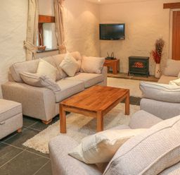 A living room with a sofa coffee table and television at Maerdy Cwtch Haverfordwest
