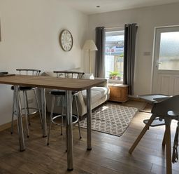 A living room with a sofa and dining table at Dog-friendly lodge, steps to St Ives train, Hayle
