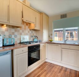 A kitchen with appliances and a window at Pet-friendly lodge with hot tub near the coast