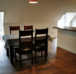 A dining room with a table and chairs in Surf-ready apartment with sea views in town