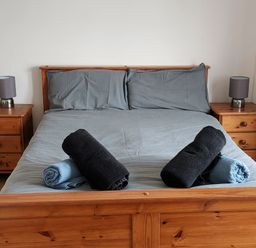 A bedroom with a bed and towels on it at Surf-ready apartment with sea views in town