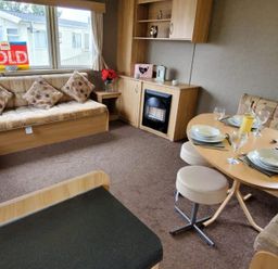 A living room with a sofa, table and fireplace at tbc in 