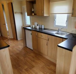 A kitchen with sink, fridge and cabinets at tbc in 