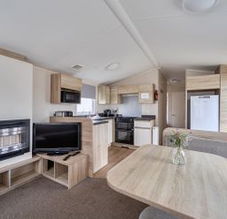 A kitchen area with a dining table and appliances at Pet-friendly lodge near Fistral Beach, Newquay