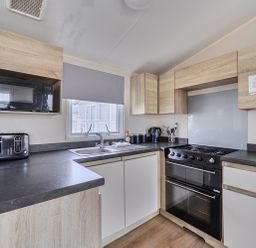 A kitchen with appliances including a cooker and microwave at Pet-friendly lodge near Fistral Beach, Fistral Beach, Newquay