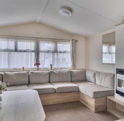 A living room with a grey sofa and a table at Pet-friendly lodge near Fistral Beach, Fistral Beach, Newquay