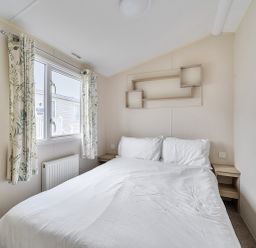 A bedroom with a bed and window at Pet-friendly lodge near Fistral Beach, Fistral Beach, Newquay
