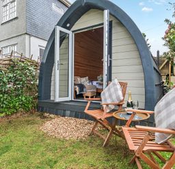 A pod with chairs and a table outside at Peaceful pod with bay views, walk to 3 beaches St Ives