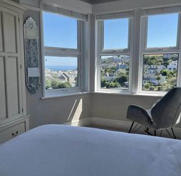 A bedroom with a wardrobe, a mirror, and a chair at tbc in 