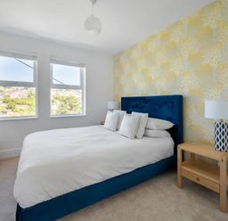 A bedroom with a bed and bedside table at tbc