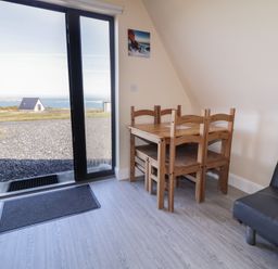 A dining area with a table and chairs at Cabin 9 Inish Beag, Gortahawk