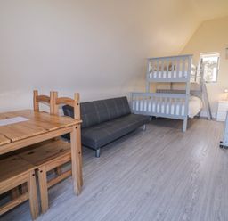 A bedroom with a bunk bed and a sofa at Cabin 9 Inish Beag in Gortahawk