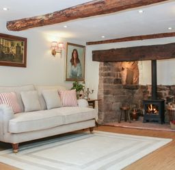 A living room with a sofa and fireplace at Upper Frogpool Cottage in Crediton