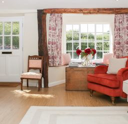 A living room with a door and window at Upper Frogpool Cottage in Crediton