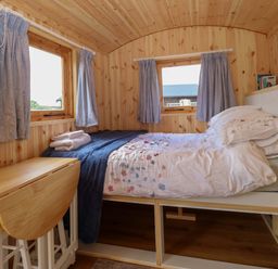 A bedroom with a bed and dining table in Hazel