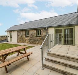 An outdoor area with a picnic table and steps at Barley Cottage in Oxwich