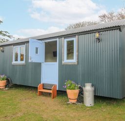 A shelter with blue door and windows set outside at Skye in Clee Hill
