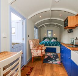 A bedroom with a bed and kitchen area at Skye in Clee Hill