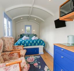 A bedroom with a bed and seating area at Skye in Clee Hill