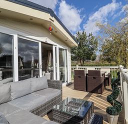 An outdoor seating area with sofa, table and chairs at 13 The Lakes in Mablethorpe