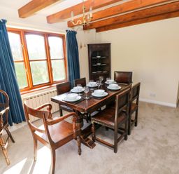 A dining room with table and chairs at Park Hall Cottage in Solva
