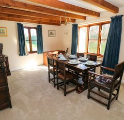 A dining room with a table and chairs at Park Hall Cottage in Solva