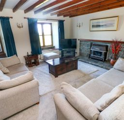 A living room with a television and fireplace at Park Hall Cottage in Solva