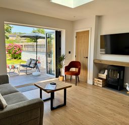 A living room with a sofa and a coffee table at Y Bwthyn in Pembrey